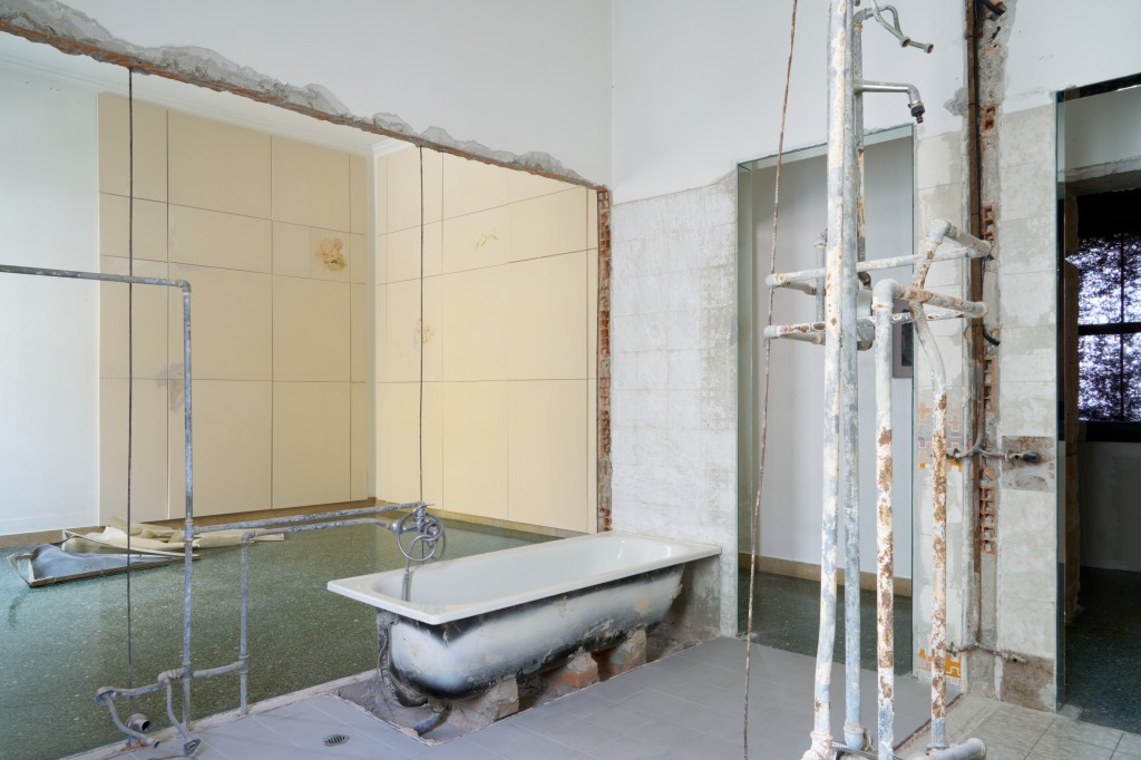 my emptiness (2025), site-specific installation using sectioned walls, excavated pipes, and a bathtub. Dimensions variable. The work suggests domestic exposure and vulnerability through architectural dissection.