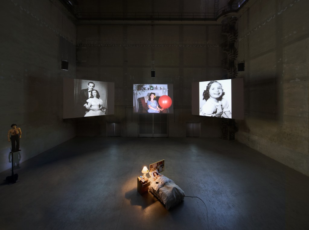Installation view of Sisters, Saints, Sibyls by Nan Goldin, featuring large-scale projections in a dark gallery at Pirelli HangarBicocca, Milan, 2025. Photo by Agostino Osio
