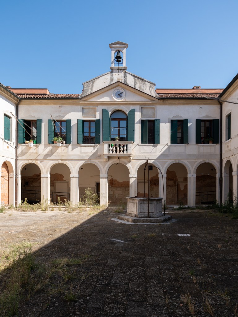 Exterior view of the former infirmary building, showing its historic architecture and weathered facade.