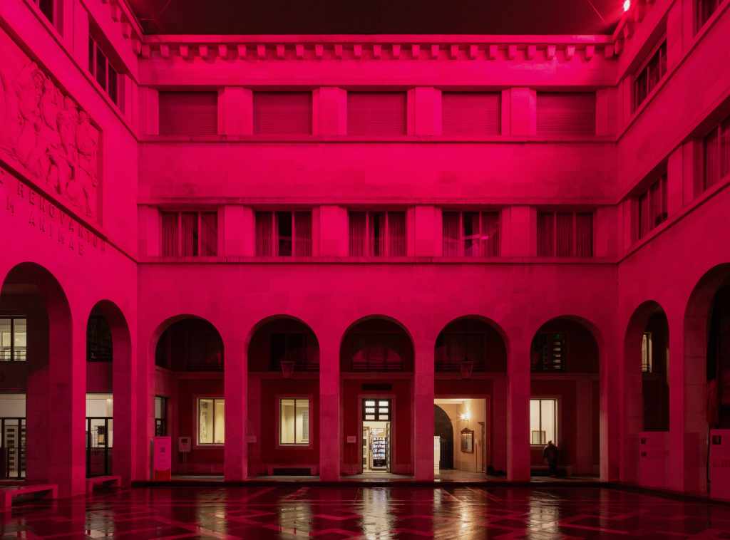 Environmental light installation Margine rosso illuminating the Cortile Nuovo of Palazzo del Bo with red-toned lighting.