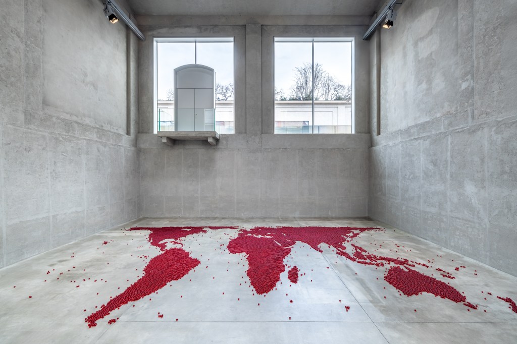 Installation view of Mona Hatoum’s Map (red) (2026), composed of numerous small red glass spheres arranged across the floor to form a map-like configuration