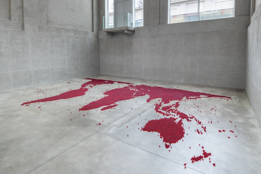 Installation view of Mona Hatoum’s Map (red) (2026), composed of numerous small red glass spheres arranged across the floor to form a map-like configuration
