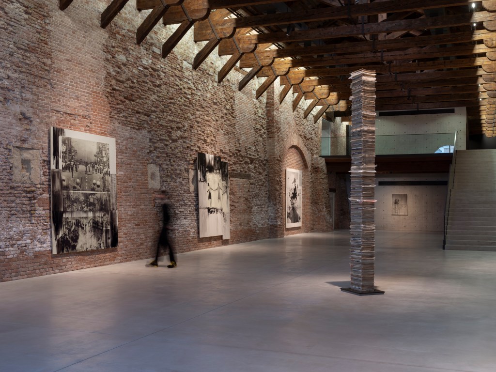 Installation view of Lorna Simpson: Third Person (2026) at Punta della Dogana, Venice, featuring Black Totem (2025) on the floor and, on the wall from left to right, Then & Now (2016), Three Figures (2014), Black Nebula (2016), and Polka Dot & Bullet Holes #2 (2016); photograph by James Wang; courtesy of Palazzo Grassi, Pinault Collection.