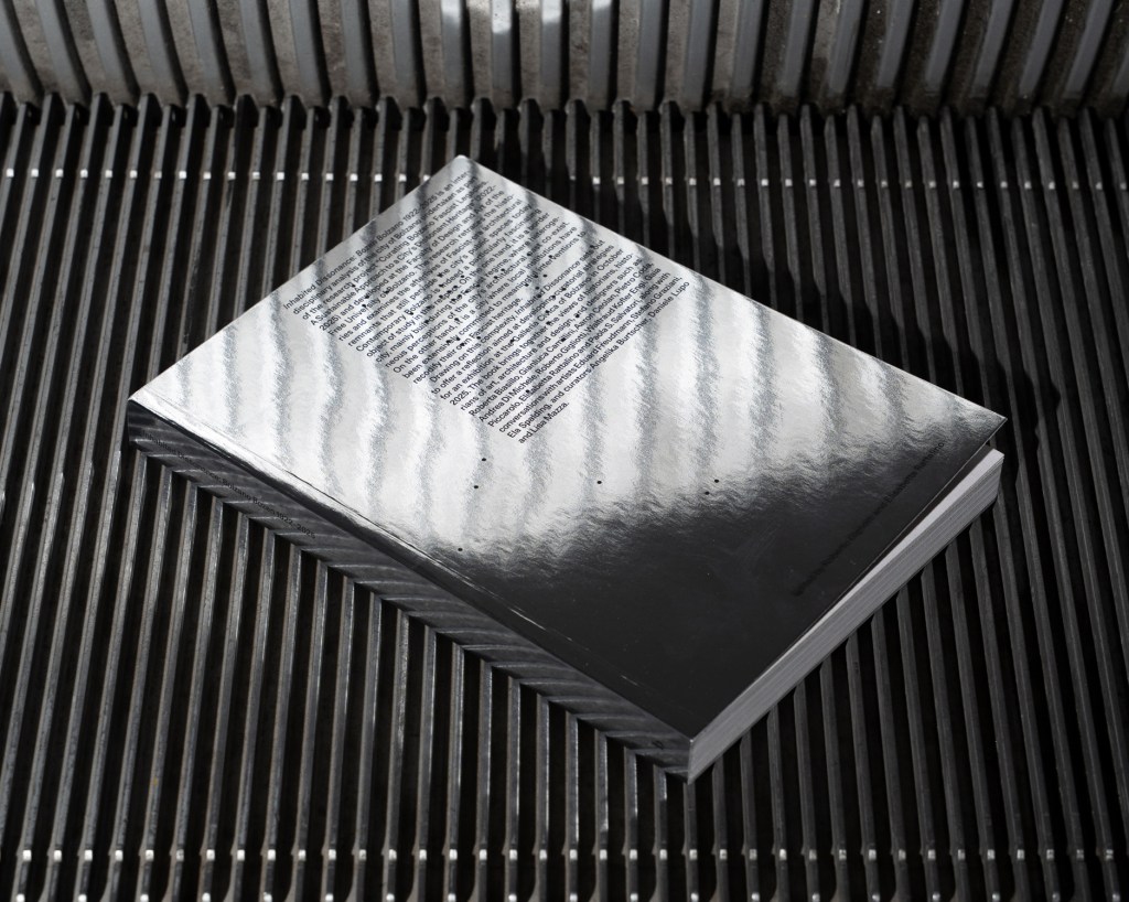 Copertina del volume “Inhabited Dissonance: Bozen Bolzano 1922–2025”, a cura di Roberto Gigliotti ed Elisabetta Rattalino, pubblicato da bruno, Venezia, 2025. Fotografia di Giacomo Bianco.