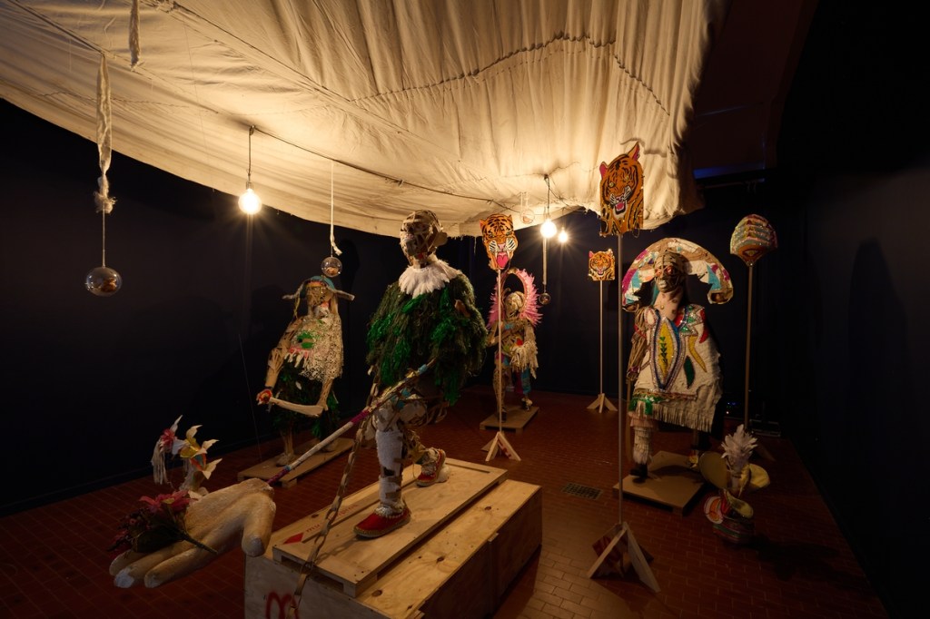Lavar Munroe (with John Beadle), However Long the Night, the Dawn Will Break (2026), site-specific installation incorporating salvaged Junkanoo costumes, used Bahamian newspapers, mixed media, and materials from John Beadle's studio