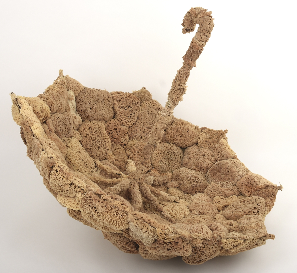 Three-dimensional assemblage consisting of an open umbrella covered with natural sponges, creating the appearance of a floating cloud and combining everyday objects with organic materials