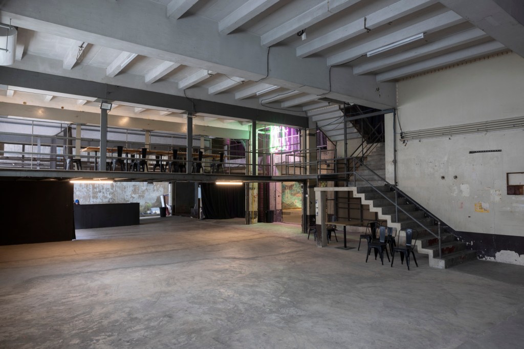 Interior of Bangkok Kunsthalle featuring raw industrial architecture with exposed brick, concrete surfaces, and open exhibition spaces