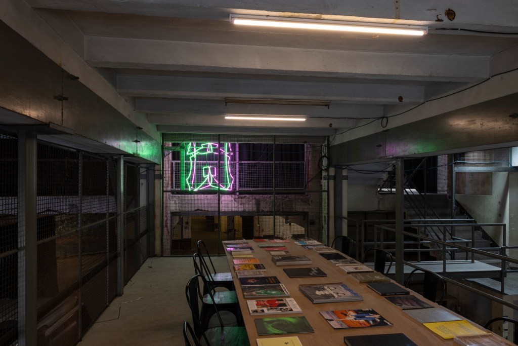 Interior of Bangkok Kunsthalle featuring raw industrial architecture with exposed brick, concrete surfaces, and open exhibition spaces