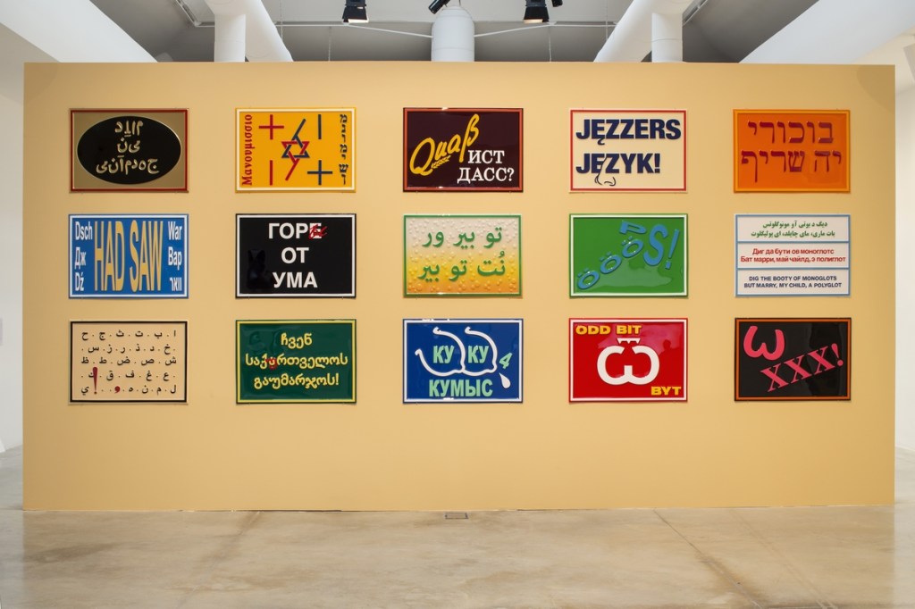 Installation view of Slavs and Tatars’ The Tranny Tease (pour Marcel), 2009–2016, showing multiple vacuum-formed plastic works with painted surfaces arranged on a wall at the Venice Biennale